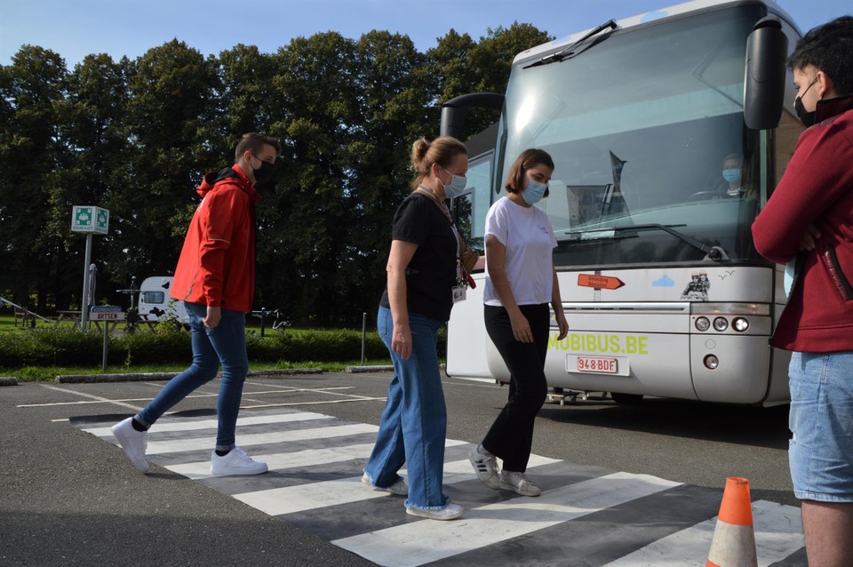 Marieke stapt over het uitrolzebrapad. Bijna elke leerling heeft nog een begeleider.