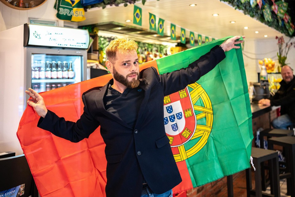 Een Portugees hijst de Portugese vlag. Zaterdag zal de spanning opnieuw te snijden zijn binnen de gemeenschap in Antwerpen.  