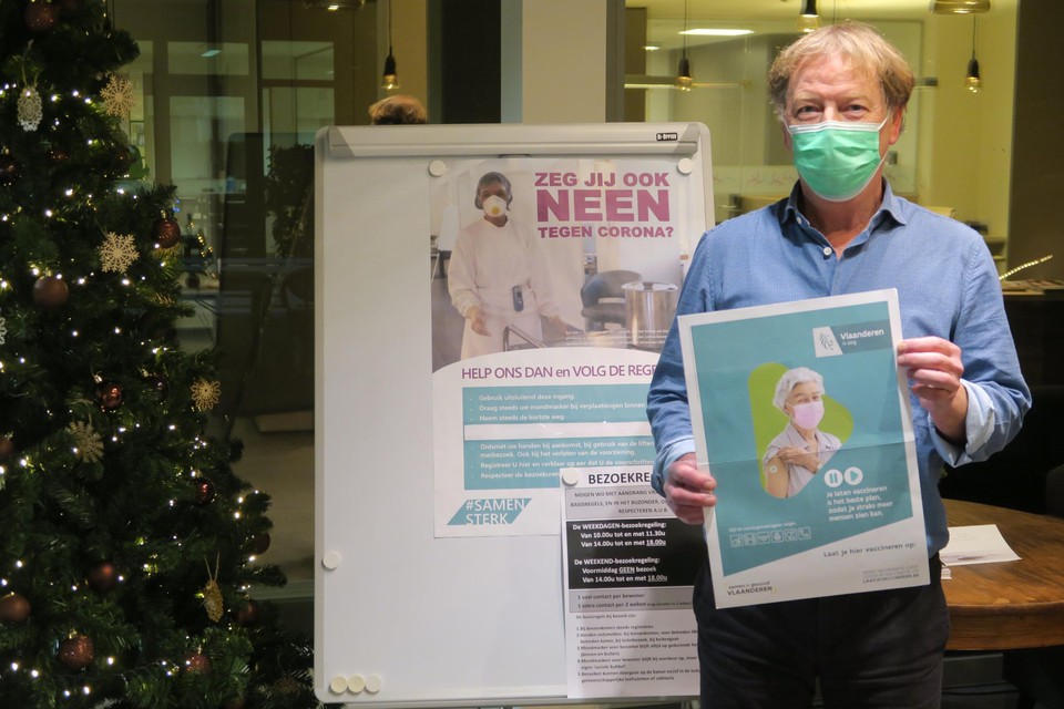 Een opgeluchte Sint-Lodewijk-directeur Chris Janssens met de officiële vaccinatiecampagneposter van de Vlaamse overheid voor de bewoners.