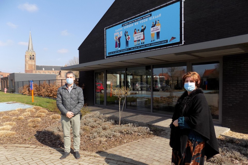 Directeur Kris Breugelmans en burgemeester Marleen Peeters van Lille staan bij het spandoek aan het woonzorgcentrum Lindelo met de oproep om je te laten vaccineren.
