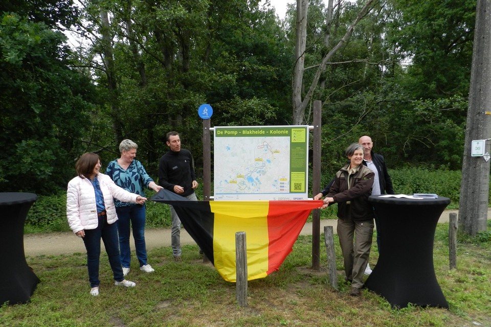 Vertegenwoordigers van de drie gemeenten, Sport Vlaanderen en ANB onthullen het infobord op het startpunt aan de parking Blakheide in Beerse.