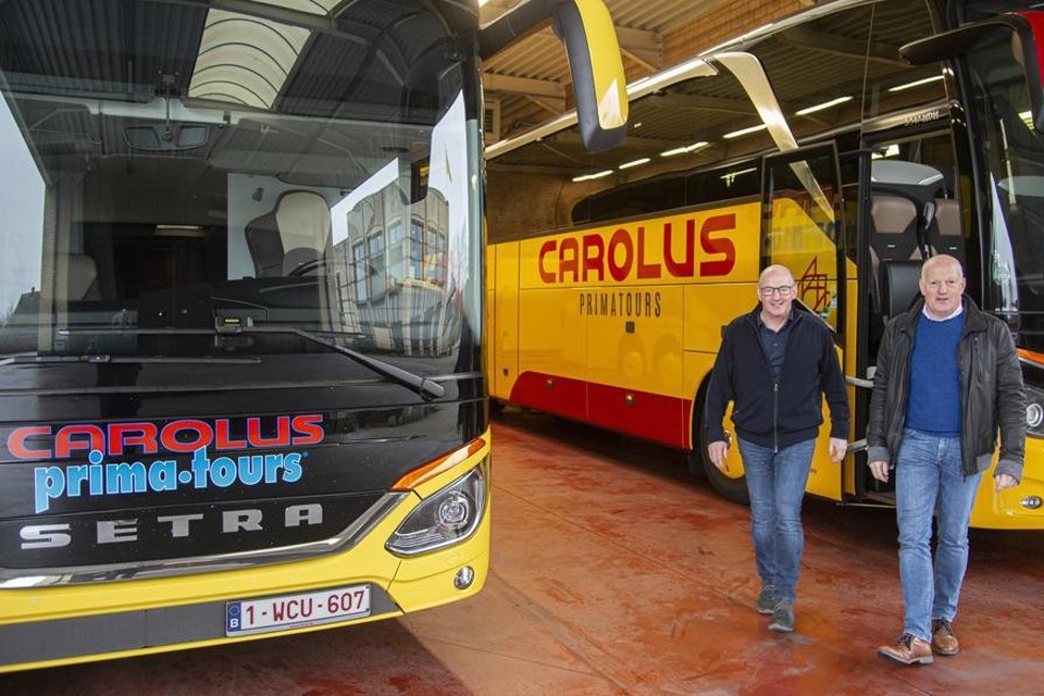 Zaakvoerders Jan en Marc Hoeks tussen hun trots: de luxebussen met Carolus-standaard.