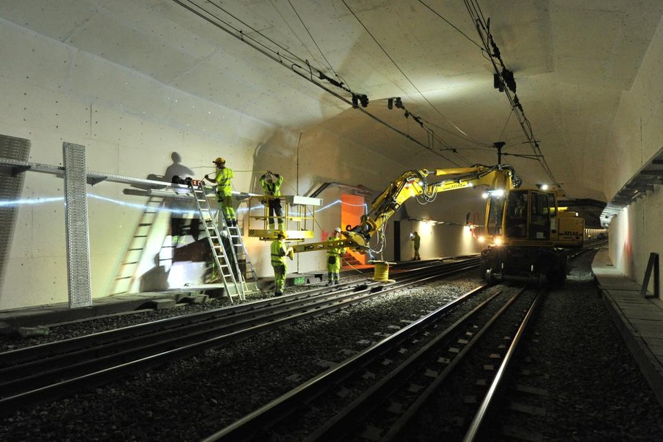Technici installeren brandwerende panelen in de ruim vijftig jaar oude spoortunnel onder de Schelde in Antwerpen.