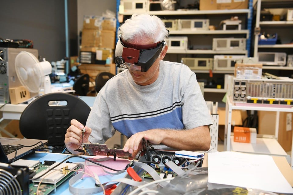 Een werknemer van Celestia Antwerp werkt aan een elektronisch apparaat. 