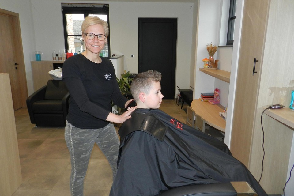 Sandy Van Den Heuvel zet de tondeuse in het haar van zoon Arne.