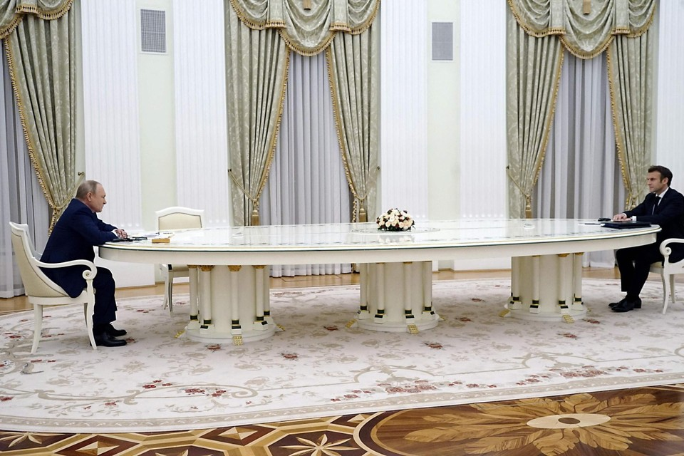 Vladimir Poetin in gesprek met de Franse president Macron, aan de intussen beruchte witte tafel.  