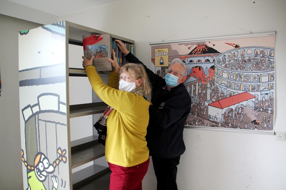Vrijwilligers Chantal en Raymond vullen de nieuwe boekenrekken in de StripARK met strips.