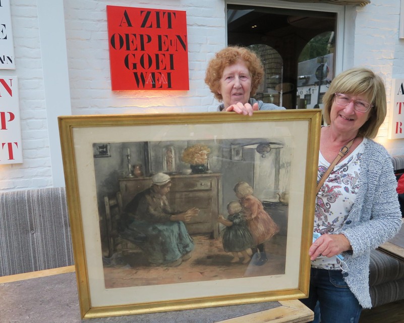De zussen Vera en Anita Ryssens met hun aangeboden schilderij. Aan de muur hangt een ‘Erik Willems’, vader van De Vogelenzang-uitbater Alain Willems.