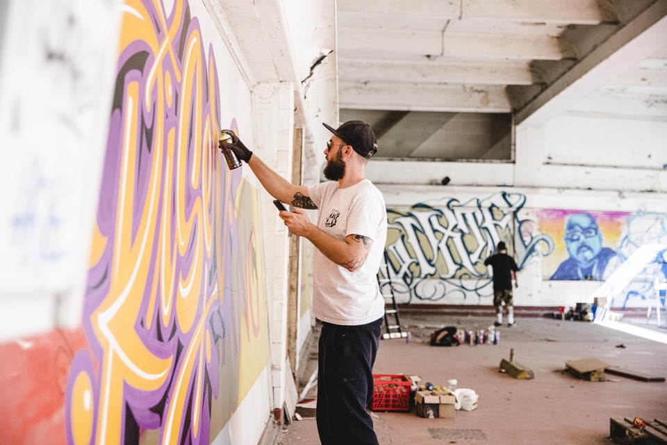 Graffitiartiest Yvon Tordoir van Aerosol Kings aan het werk op de Markgravelei.