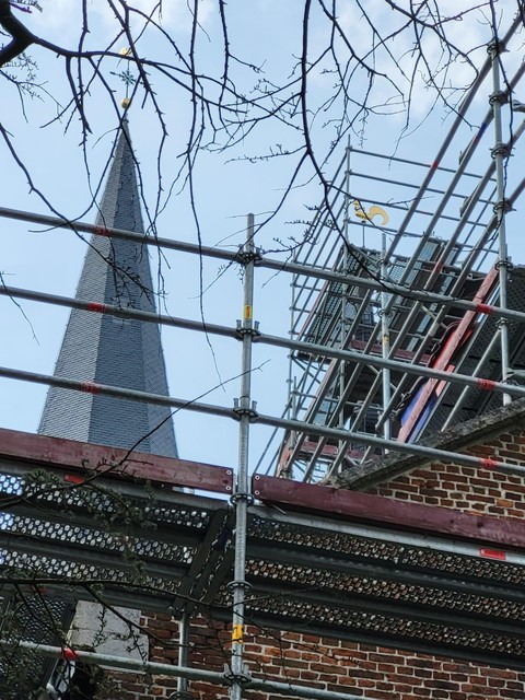 De stellingen rond het dak van de hoge toren zijn al verwijderd.