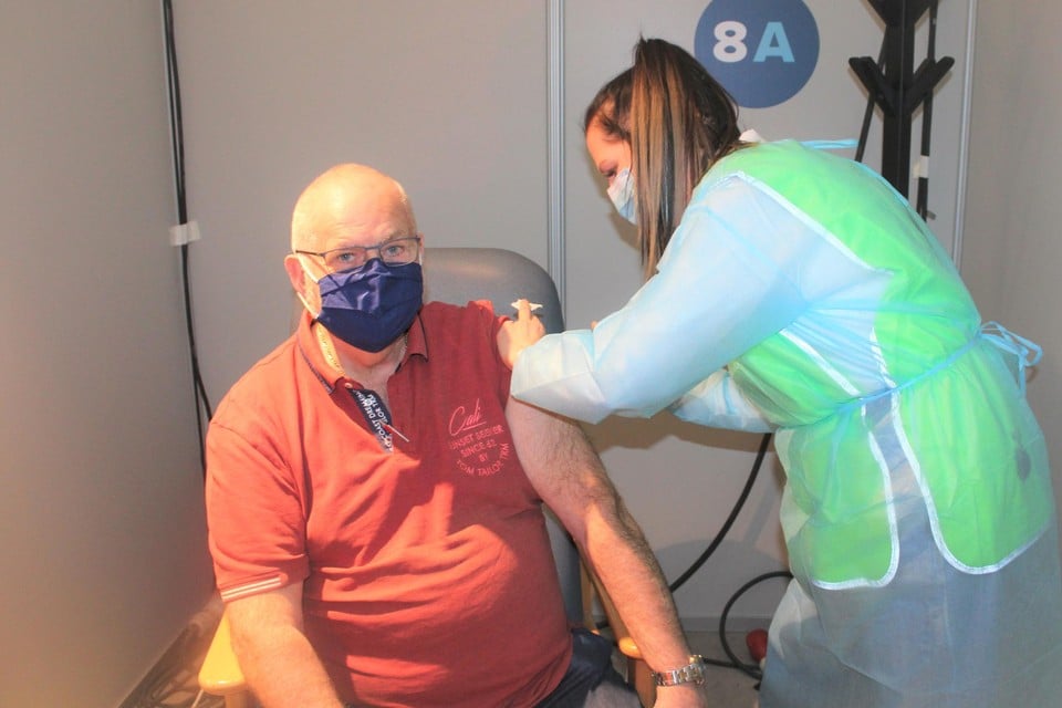 Studente Lynn Van Dessel geeft Robert Van Eylen zijn coronavaccin.