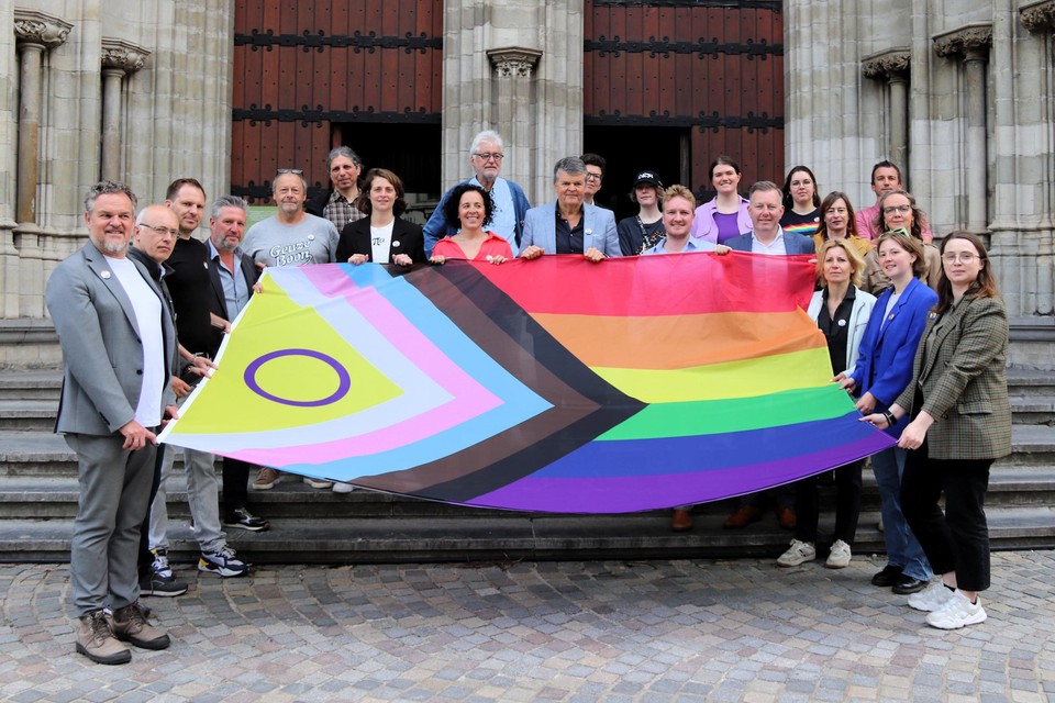 Een delegatie van de gemeenteraad en lokale LGBTQIA+-organisaties met de nieuwe pridevlag.