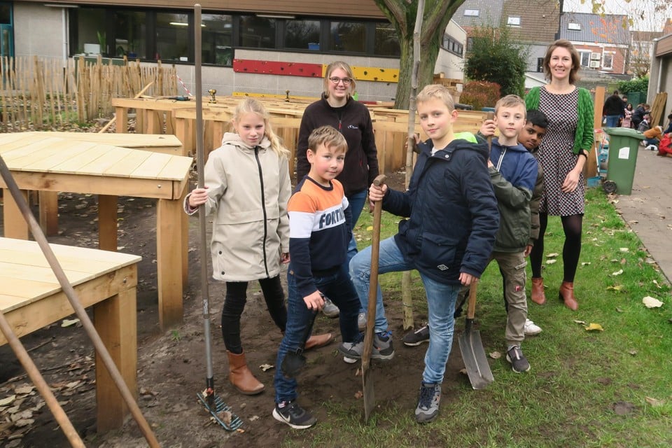 Directeur Audrey Festraets en enkele leerlingen van GO!-school Ter Linde in Schoten staken zelf mee de handen uit  de mouwen om hun speelplaats te vergroenen.