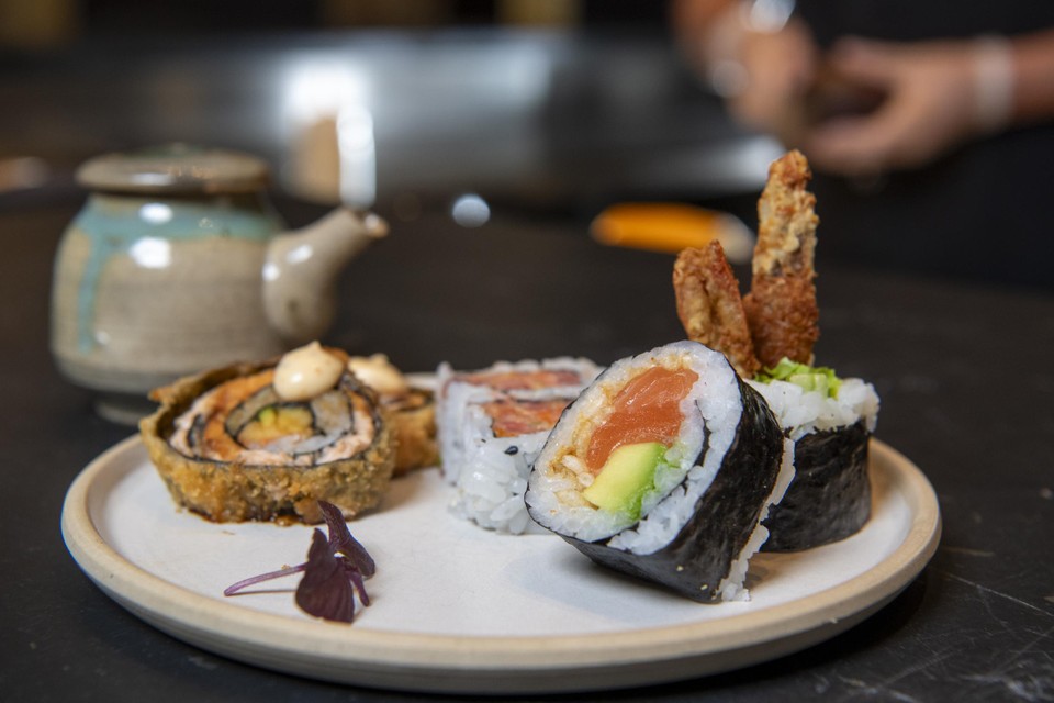 Een sushi combo met fried rolls van zalm, spicy tonijn uramaki en fotomaki kamikaze met zalm en tempura van scampi.