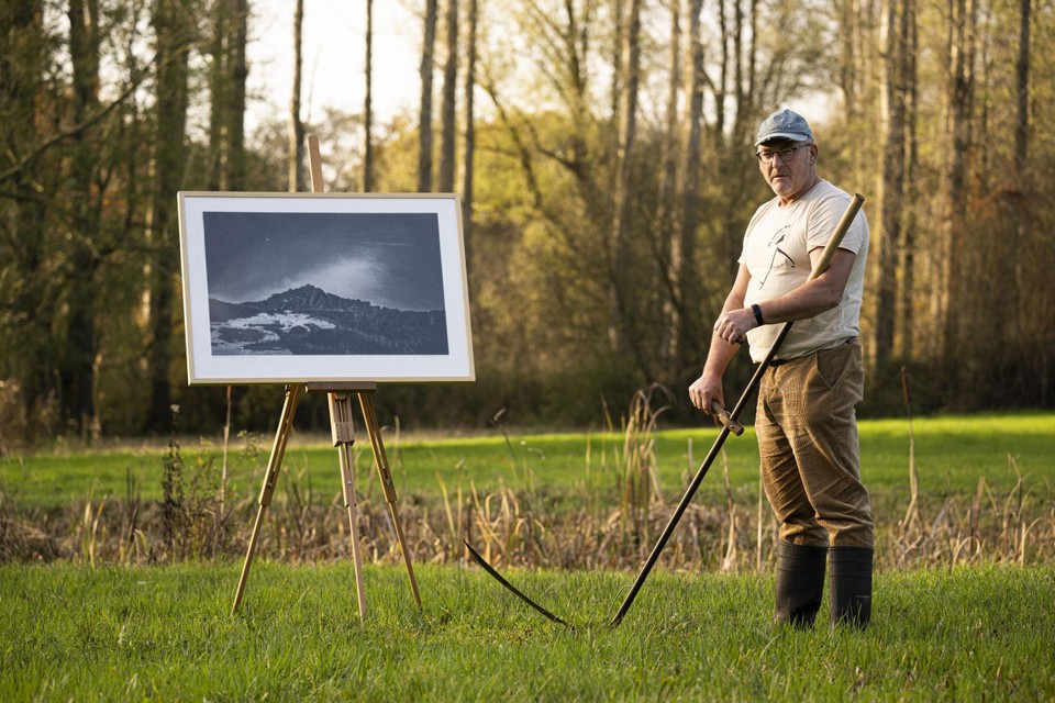 Dominique Van Huffel zeist de beemden in de vallei van ’t Merkske, op de achtergrond een tekening die hij maakte. 