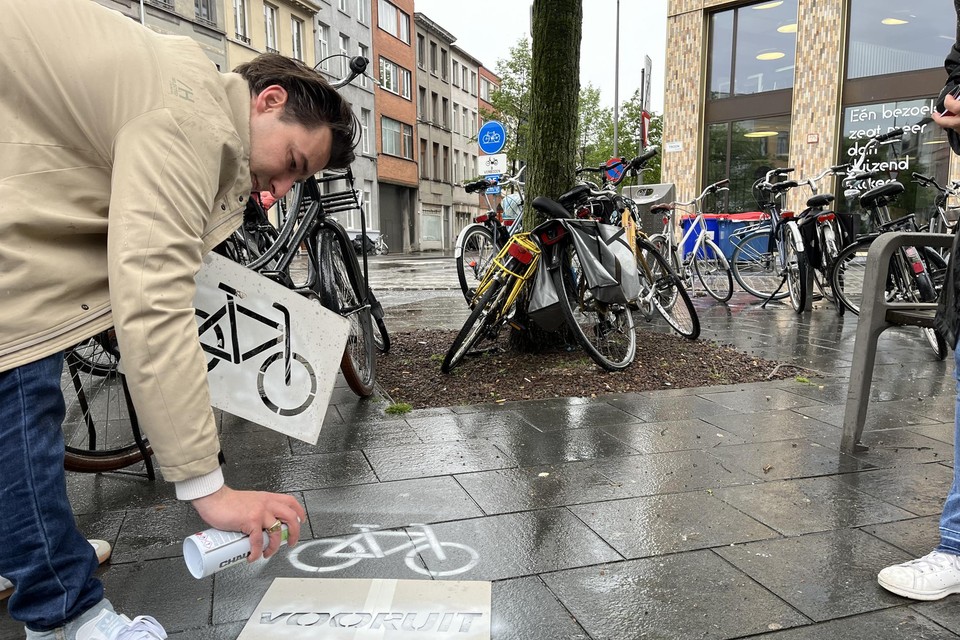 Matthias Verstraeten schildert met krijt een fietslogo op de Troonplaats.