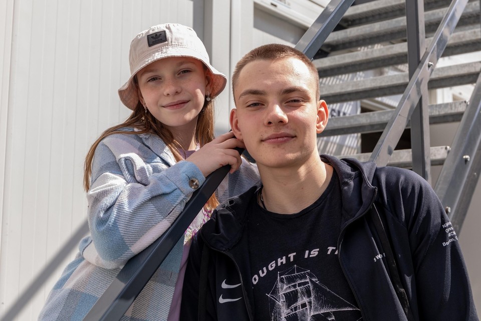 De jonge Oekraïner Yuri (17) met zijn zusje Anna voor een van de afgewerkte woonunits op Linkeroever. Hun ouders wilden niet op de foto.  