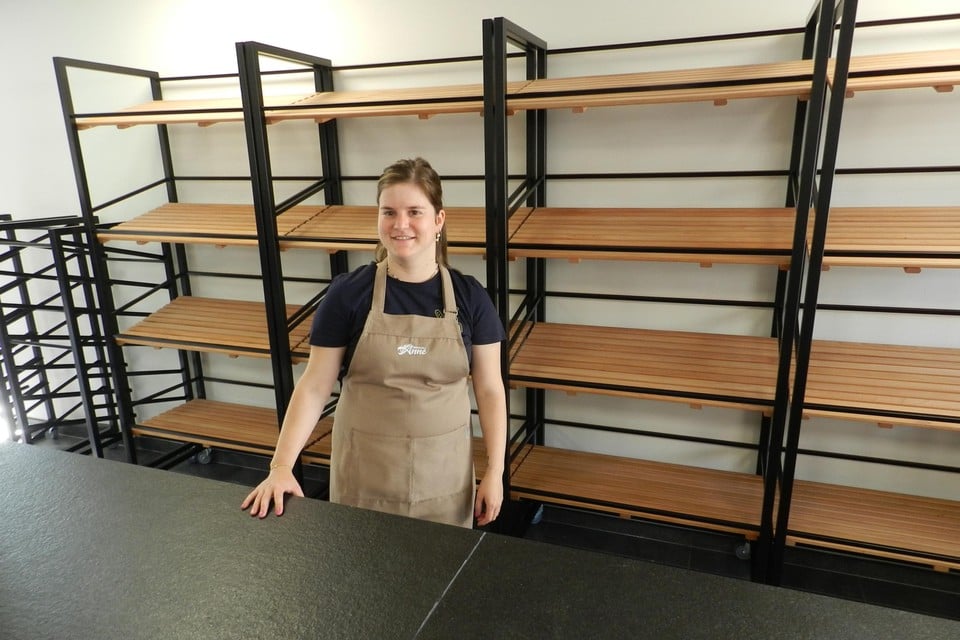 Anne Kenis vult vrijdagochtend voor de eerste keer de broodrekken in haar nieuwe winkel.