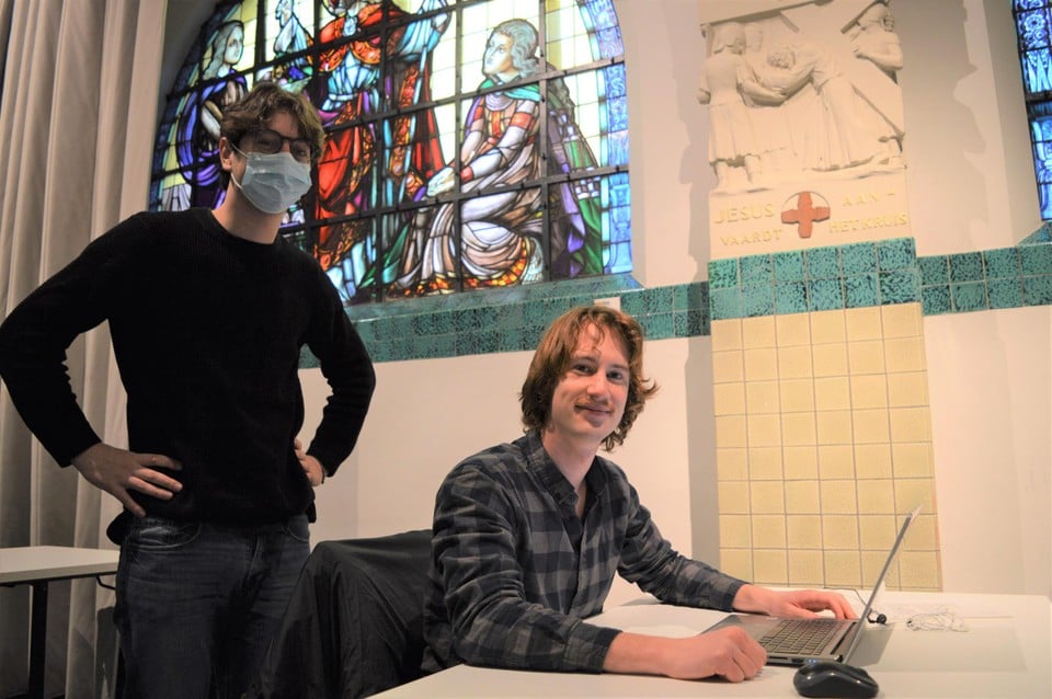 Jan (rechtstaand) en Joren achter zijn laptop in De Kapel in Zoersel.
