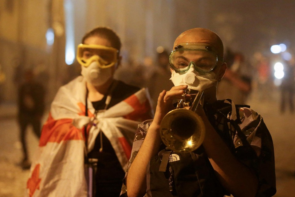 Protest in Tbilisi, met mondmasker en zwembril tegen het traangas.