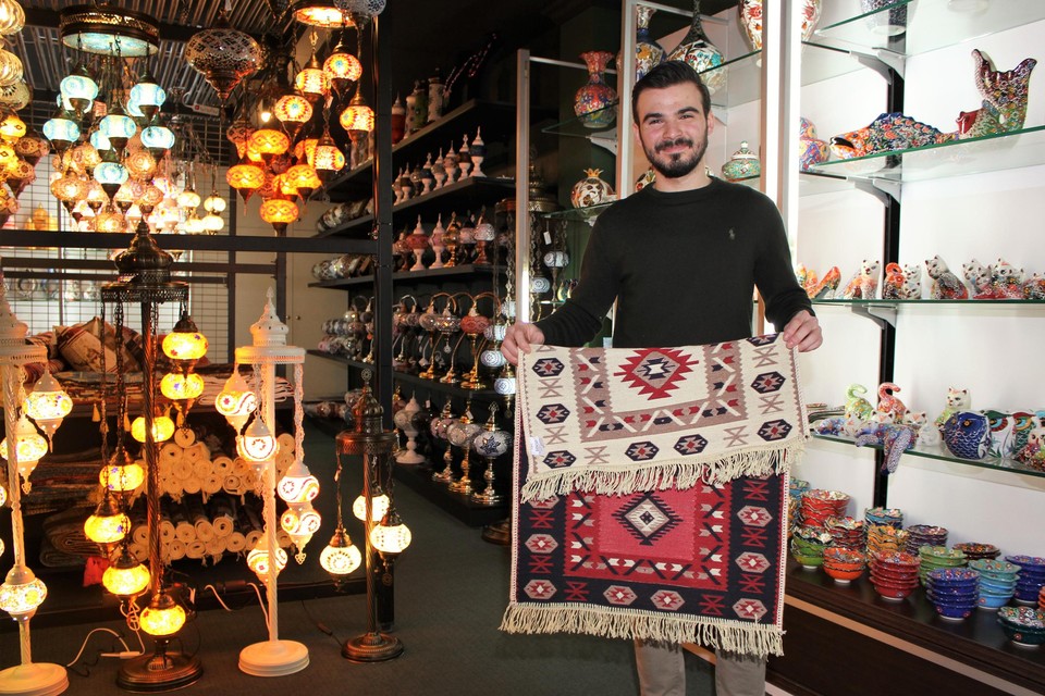 Berat Yilmaz toont een Turks kilimtapijt.