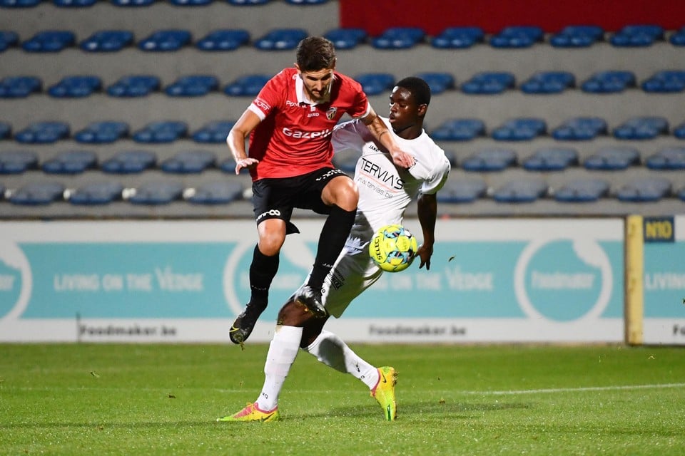 Gianni Vets (rood) ontwijkt de poging van Saka Gafar Oriyomi om de bal te onderscheppen in het duel tussen Houtvenne en Lyra-Lierse.