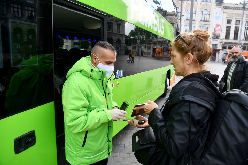 Chauffeur Youssouf (35) controleert het ticketje van Cindy (51). Zijn bus mag maar halfvol zitten door de Nederlandse regelgeving. De Belgische en Franse regels laten een volle bus toe. 