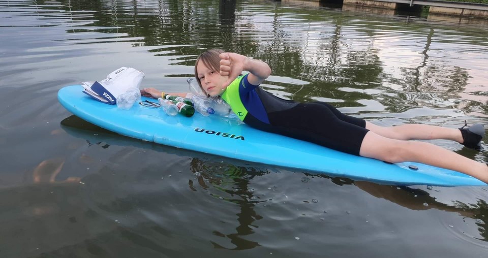 Sup-boarder Jeff met lege bierflesjes en een pizzadoos op het Netekanaal. Triestig, vindt hij zelf.