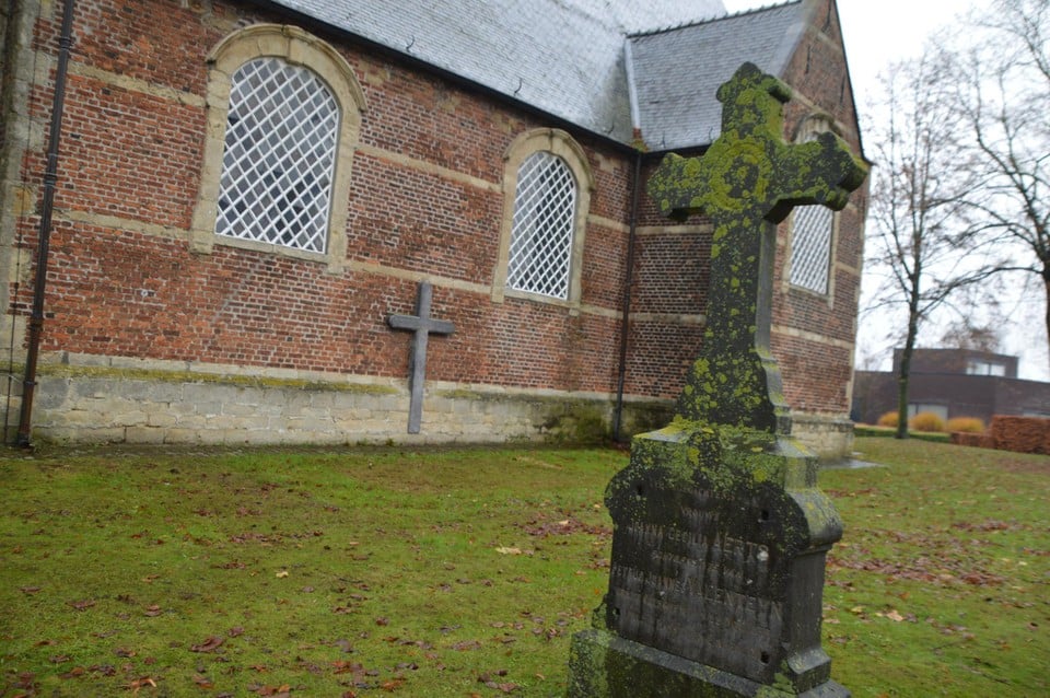 Het grafkruis aan de kerk in Ranst-Millegem. 