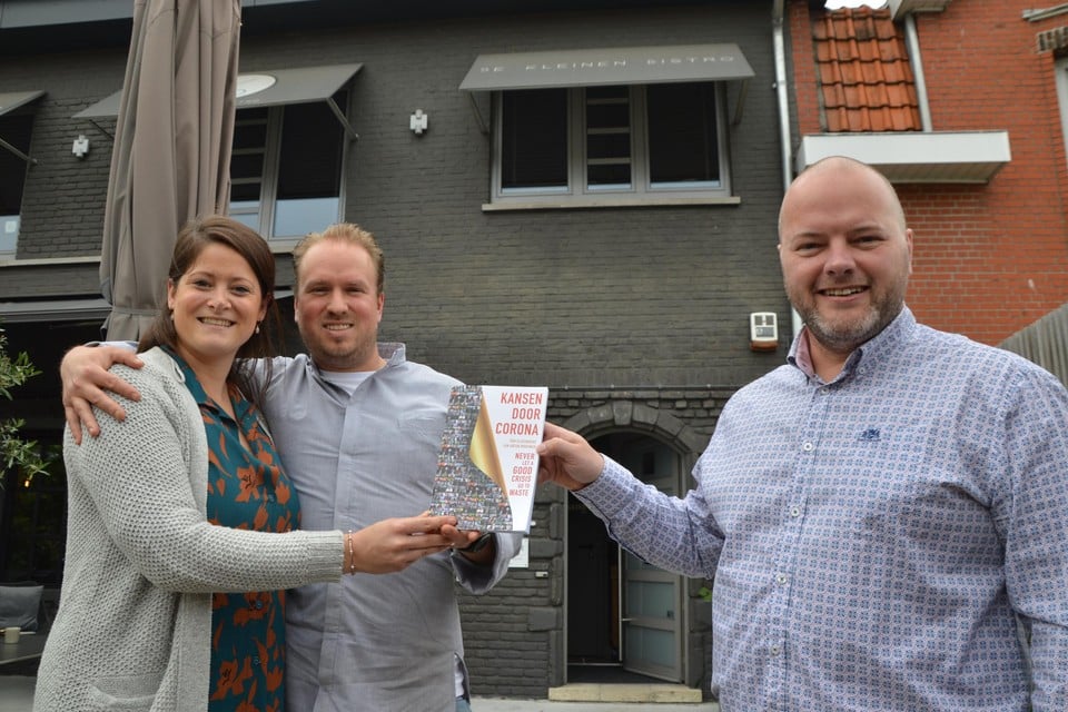 Gastvrouw Thari De Pooter en chef-kok Lawrence Elliott van De Kleinen Bistro krijgen het eerste exemplaar van co-auteur Tom Sleeuwaert.