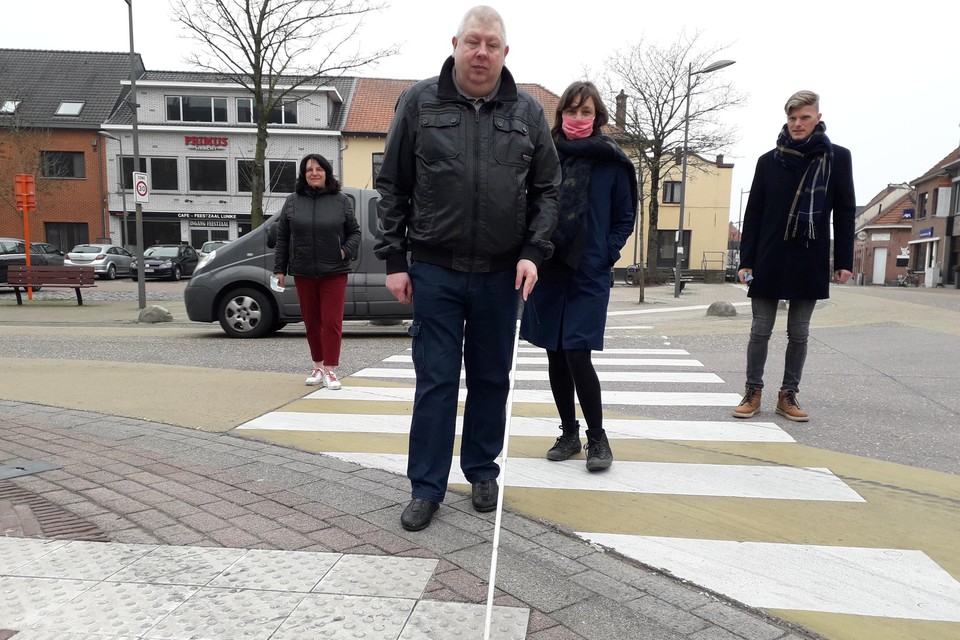 Buurtbewoner en slechtziende Gunther Van Elsacker test de nieuwe reliëftegels aan het Huffelplein.