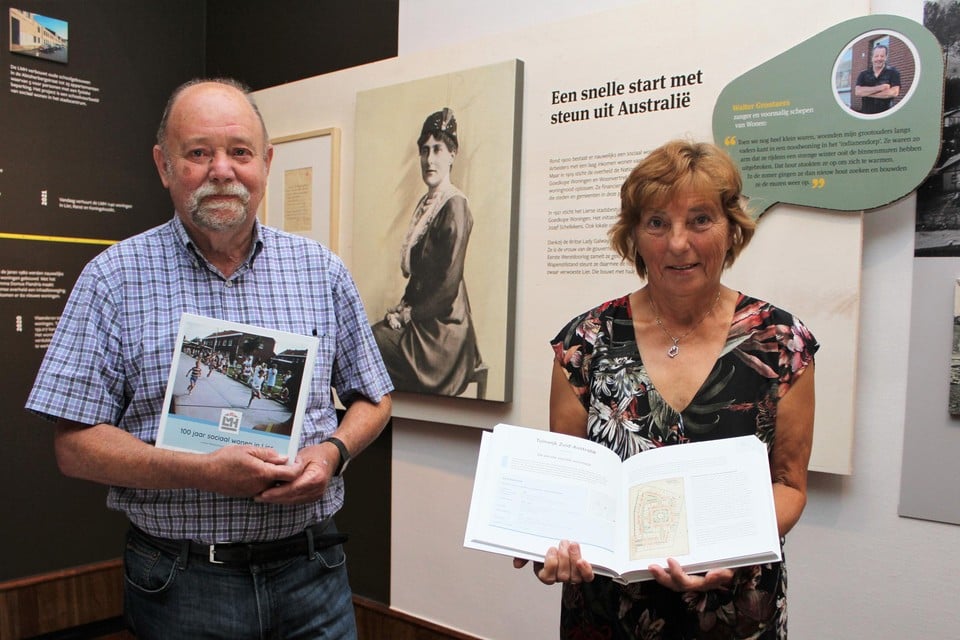 Auteurs Hugo De Bot en Greet Vervloet tonen het jubileumboek bij een van de infopanelen op de expo.