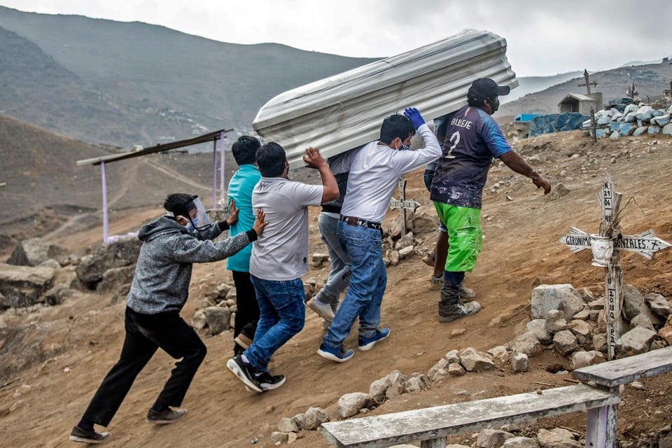 Nabestaanden begraven een covid-slachtoffer nabij Lima. In Peru zijn sinds de eerste coronadode gemiddeld bijna dubbel zoveel mensen overleden als normaal  