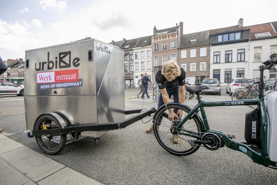 Een medewerker van Urbike bevestigt de boxcontainer aan de bakfiets van Werkmmaat.