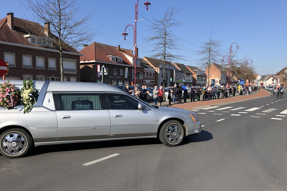 De erehaag applaudisseert als de lijkwagen passeert.