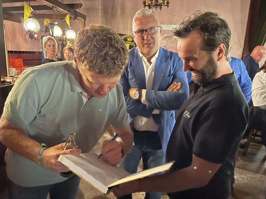 Hans Somers tekent het boek voor Eric Gerets, Eric Van Meir kijkt toe.