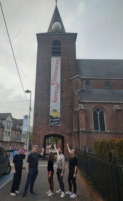 Enkele kandidaten van de nieuwe politieke partij Ons 2340 staan bij de kerk van Vlimmeren met de intussen bekende Maan van Vlimmeren.