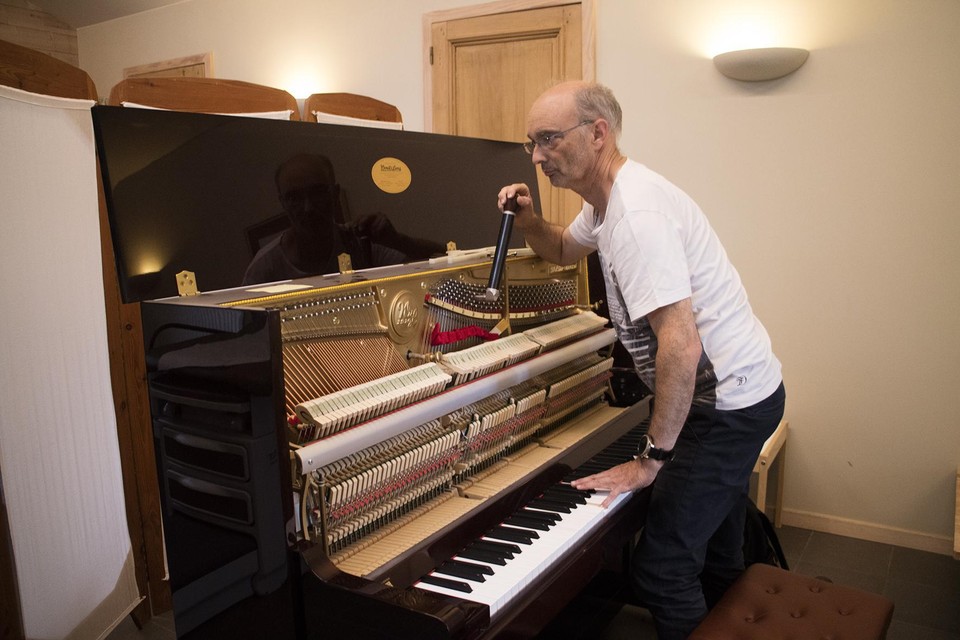 Frederic Van Hille stemt de piano.