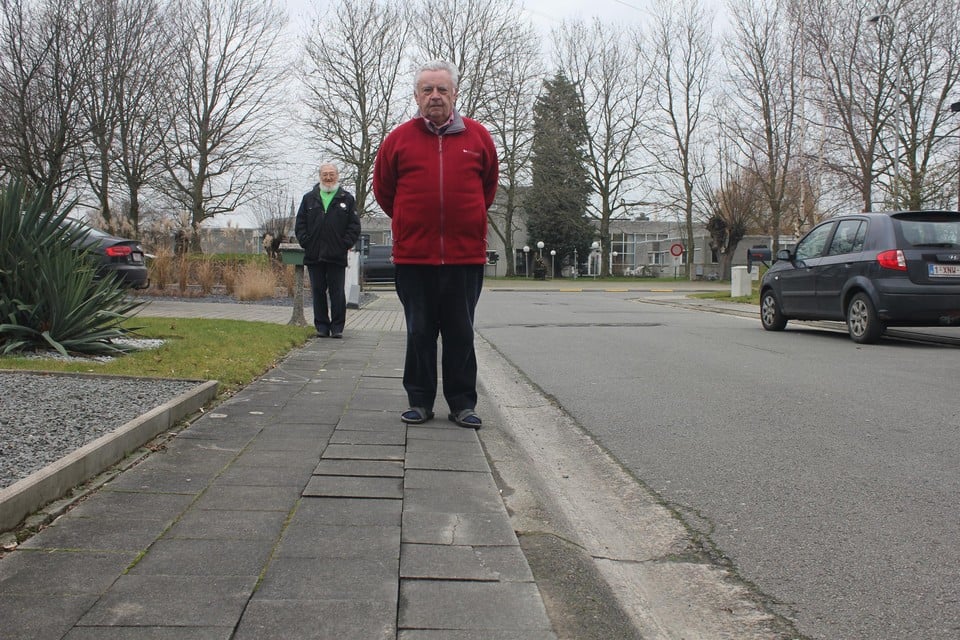 Freddy Smet, met achter hem Patric Gorrebeeck, bij een reeks losse stoeptegels voor zijn huis.