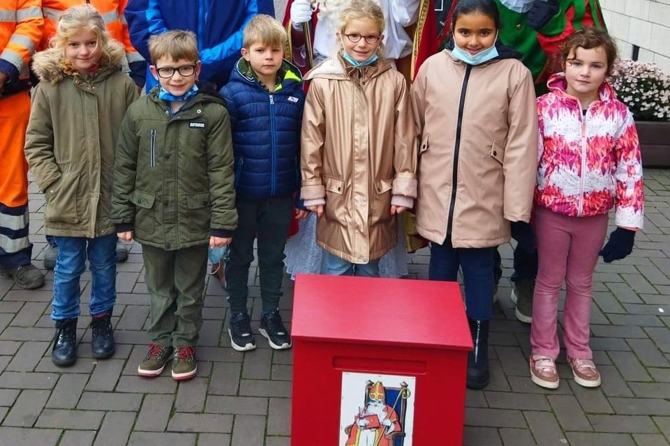 De rode brievenbus was zo zwaar geladen dat Sinterklaas de hulp moest inroepen van twee gemeentewerkers en leerlingen van basisschool Sint-Clara. 