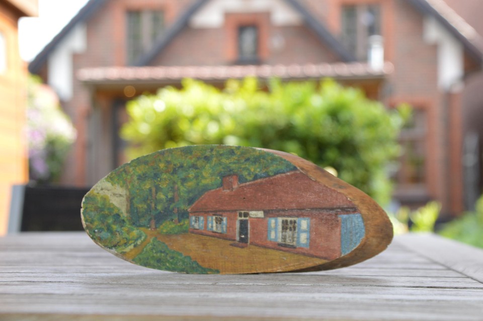 De beschilderde boomschijf die verstopt zat achter lood aan de schouw. Het koppel herkende er direct ’t Boshuisje in, waar ze vlakbij wonen.