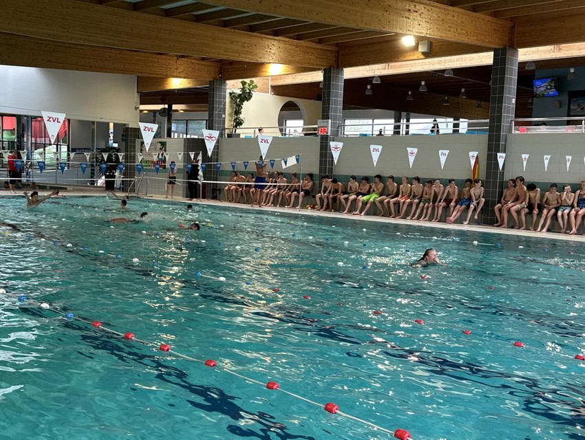 Na het hindernissenparcours zwemmen de leerlingen baantjes in het zwembad.