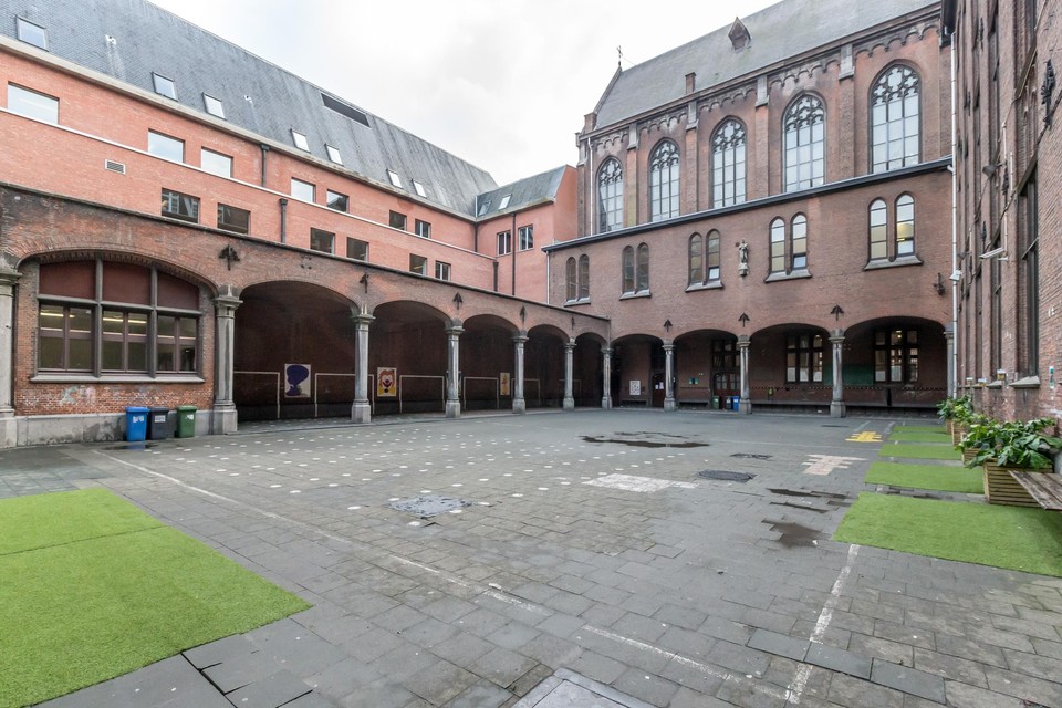 Een van de speelplaatsen van Sint-Jan, waar je in het midden nog duidelijk het oorspronkelijke neogotische gebouw herkent.  