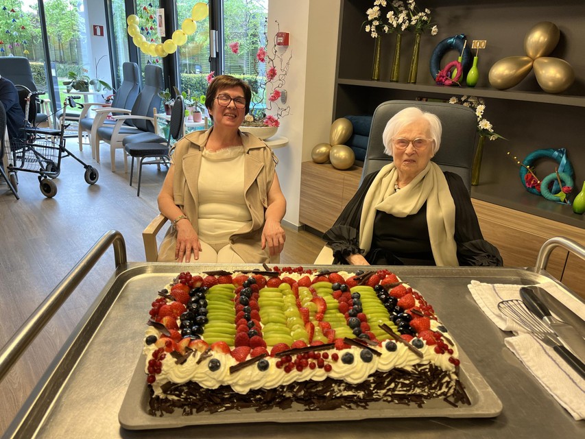 De 100-jarige Anna Van Hemelen en haar dochter Marleen Vanlommel kijken watertandend naar de grote verjaardagstaart in het dagverzorgingscentrum van Aquamarijn in Kasterlee.