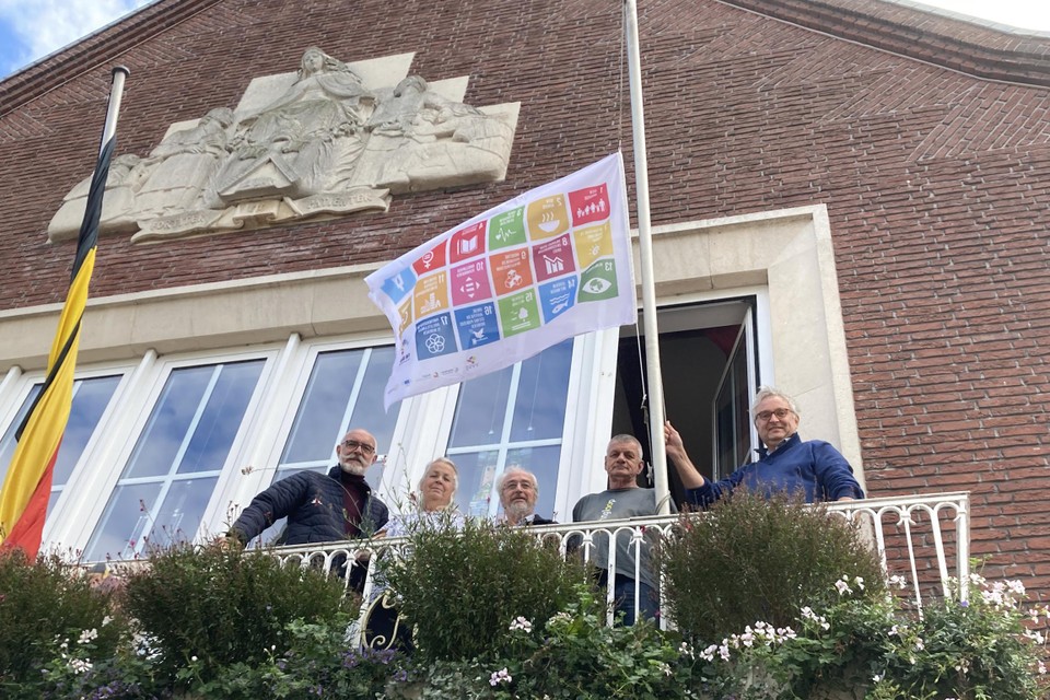 Essen geeft startschot van Week van de Duurzame Gemeente.Enkele vrijwilligers poseren met de SDG-vlag op het balkon van het gemeentehuis.  