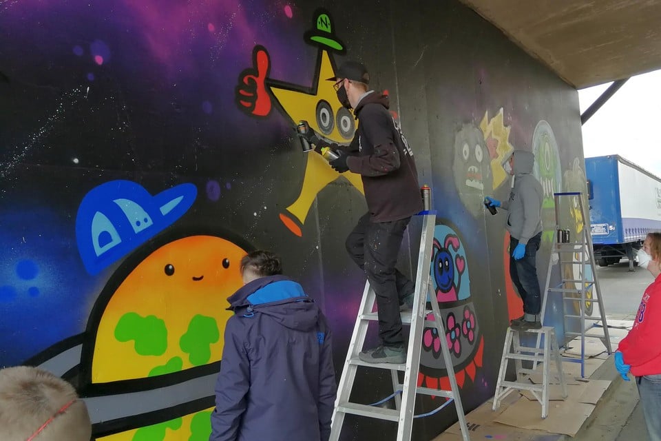 Sterren, planeten, ruimtetuigen en aliens: de jongeren van MPI Oosterlo leefden zich met graffiti uit op de kanaalmuur in Geel-Ten Aard.