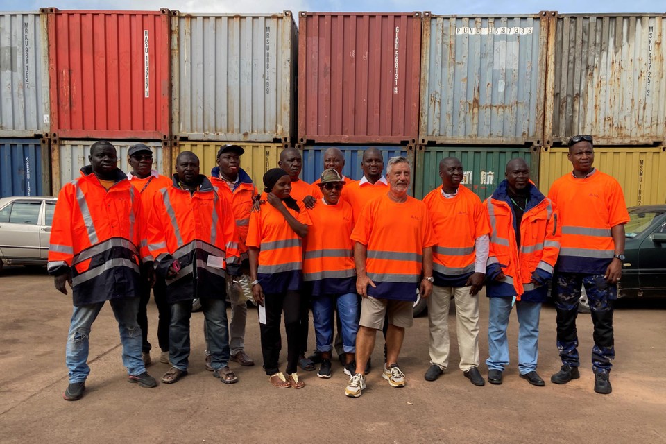 Walter Peeters tussen Gambiaanse havenarbeiders met veiligheidskleding van de Port of Antwerp die er goed van pas komt. 