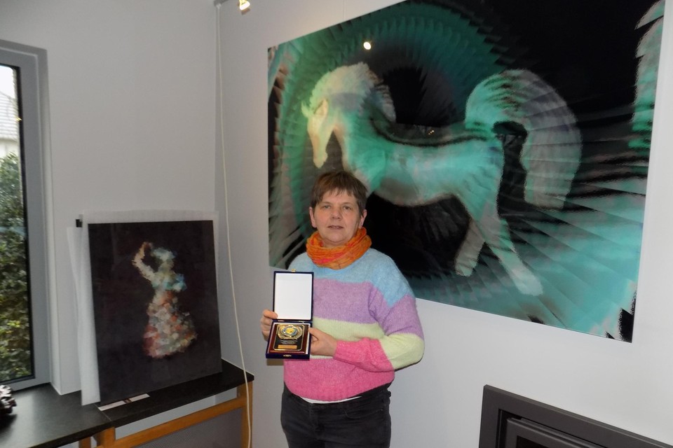 Kunstenares Anita Fleerackers uit Gierle toont haar gouden medaille bij twee van haar bekroonde digitale kunstwerken, Crazy Horse en Fun.
