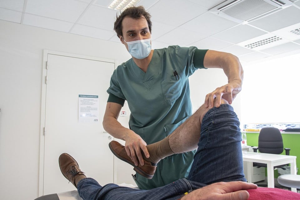Dokter Steven Claes onderzoekt de stabiliteit van een knie van een patiënt. 