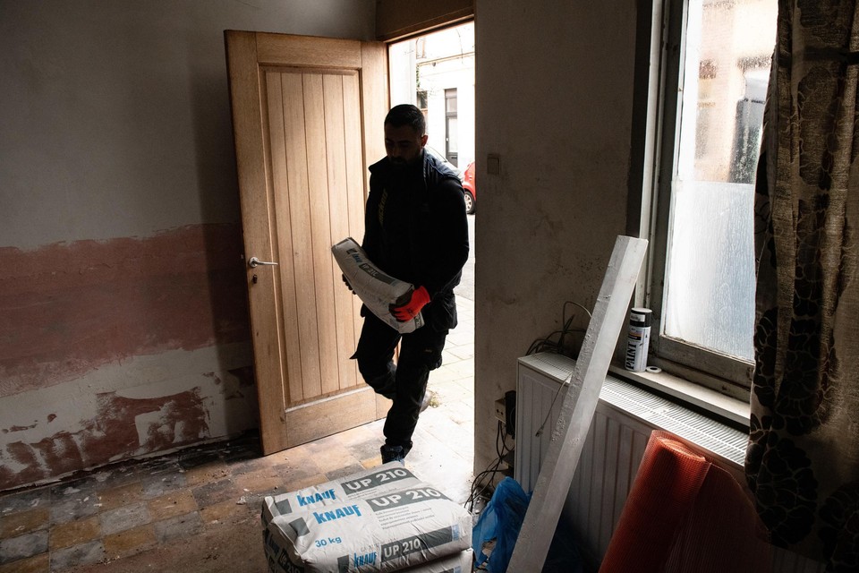 Een man draagt materiaal aan om een woning te renoveren. 